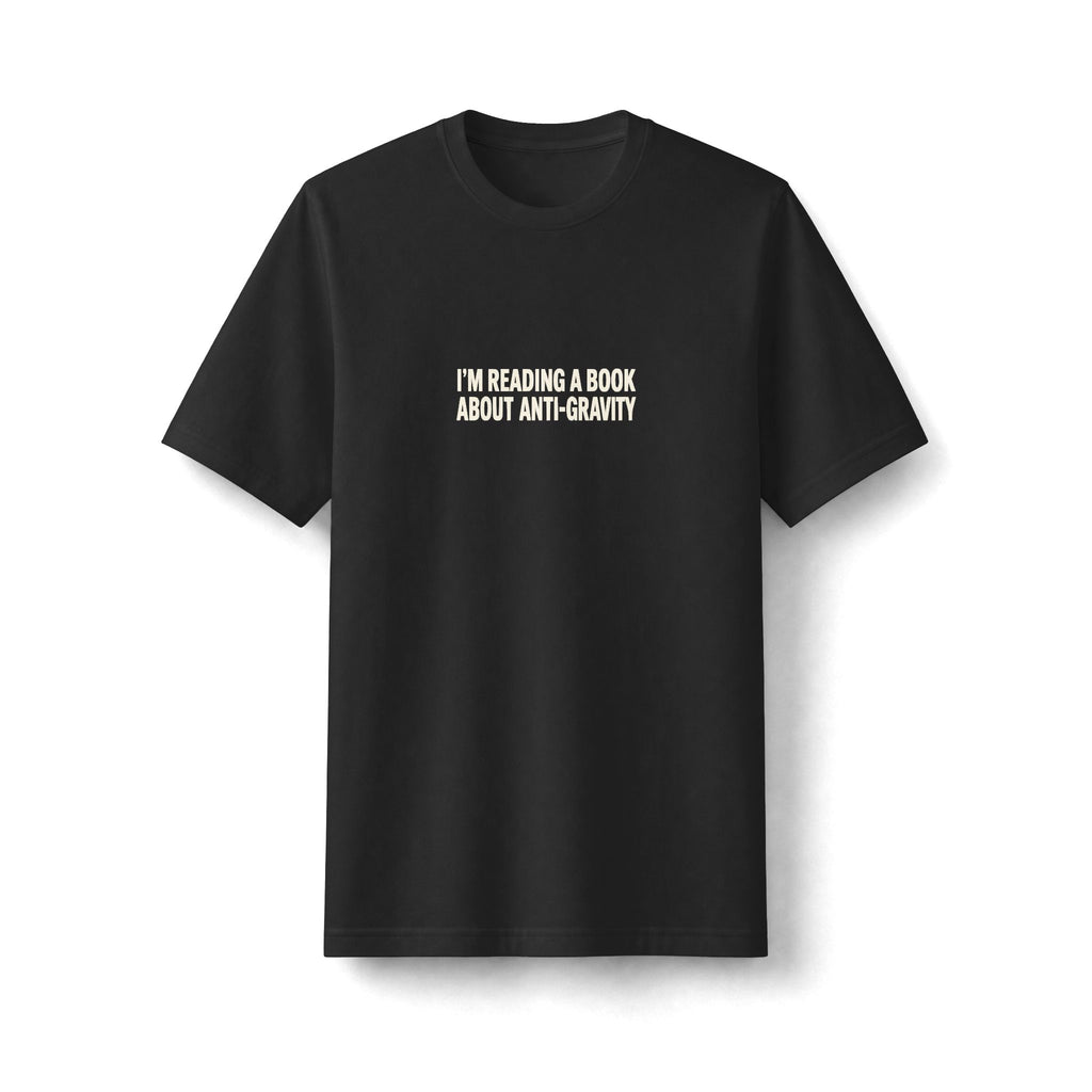"Anti-Gravity Book" funny couples graphic on a black Next Level heavyweight oversized tee - Couples Therapy Apparel